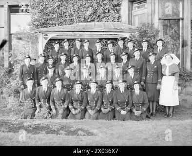 SAR LA DUCHESSE DE KENT, PRÉSIDENTE DU WRNS VISITE DES ÉTABLISSEMENTS NAVALS. 1940. - Groupe de WRNS à Rosyth, SAR au centre avec le surintendant de WRNS Marina, Princesse (Duchesse de Kent) Banque D'Images