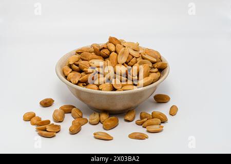 cacahuète salée rôtie dans le bol bien brun rôti ajouté avec du sel capturé sur fond blanc Banque D'Images