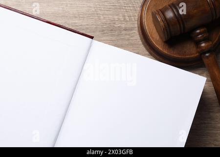 Droit. Livre ouvert et marteau sur table en bois, vue de dessus Banque D'Images