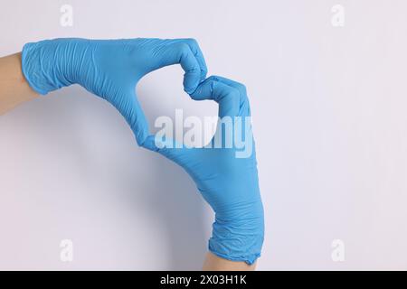 Médecin montrant un geste cardiaque avec les mains sur fond blanc, vue de dessus. Espace pour le texte Banque D'Images