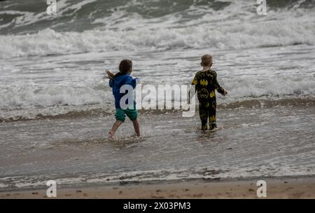 Bournemouth Dorset 9 avril 2024 Météo britannique ; les visiteurs apprécient le soleil printanier malgré les vents violents et la grande houle des tempêtes nocturnes. Out for a paddle Credit : Ian Davidson/Alamy Live News Banque D'Images