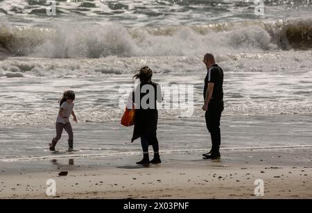 Bournemouth Dorset 9 avril 2024 Météo britannique ; les visiteurs apprécient le soleil printanier malgré les vents violents et la grande houle des tempêtes nocturnes. Famille sur la plage crédit : Ian Davidson/Alamy Live News Banque D'Images