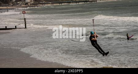 Bournemouth Dorset 9 avril 2024 Météo britannique ; les visiteurs apprécient le soleil printanier malgré les vents violents et la grande houle des tempêtes nocturnes. Zipline Credit : Ian Davidson/Alamy Live News Banque D'Images