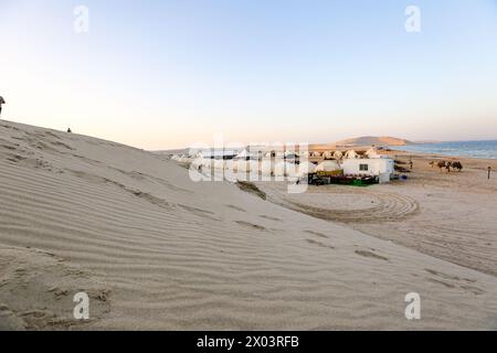 Tentes au camp du désert QIA à la mer intérieure dans le golfe Persique au coucher du soleil. Moyen-Orient, péninsule arabique. La mer intérieure est une destination touristique majeure, Qatar Banque D'Images