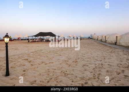 Tentes au camp du désert QIA à la mer intérieure dans le golfe Persique au coucher du soleil. Moyen-Orient, péninsule arabique. La mer intérieure est une destination touristique majeure. Qatar Banque D'Images