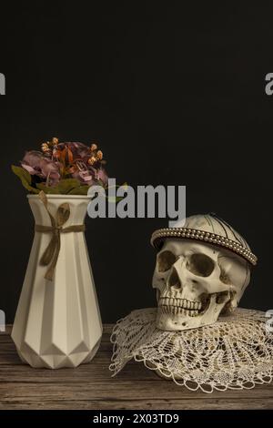 Une nature morte avec un crâne sur un tapis à côté d'un vase avec des fleurs Banque D'Images