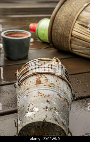 Pots de fleurs vides sur le plancher en bois avec des pots en métal rouillé au premier plan Banque D'Images