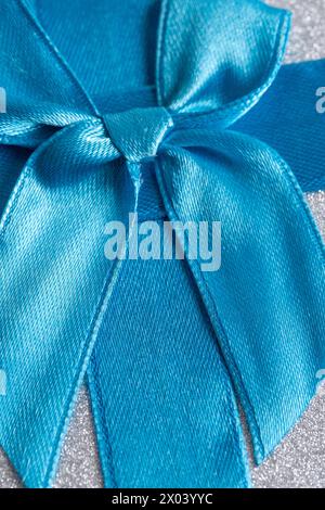 Ruban de satin bleu sur fond argenté. Gros plan Banque D'Images