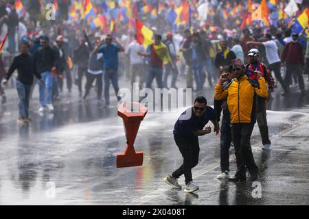 Les monarchistes affrontent la police au Népal des manifestants pro-monarchiques népalais lancent des pierres et d'autres objets physiques vers la police népalaise après avoir été empêchés de marcher plus loin dans la zone d'accès restreint près de Singha Durbar, capitale administrative de la nation himalayenne le 9 avril 2024. Des milliers de pro-monarchistes et de cadres du parti Rastriya Prajatantra RPP ont frappé les rues de Katmandou en affrontant à nouveau le personnel de sécurité alors qu'ils tentaient de pénétrer dans la zone d'accès restreint. Le RPP, un parti de droite pro-monarque, a dirigé et appelé à protester pour réclamer la restauration de la monarchie et de l'Hindu kingdo Banque D'Images