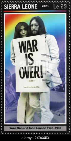 Lennon et Yoko Ono avec le signe 'War is over' sur le timbre Banque D'Images