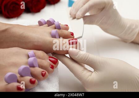 Pédicuriste classant les ongles des orteils du client dans un salon de beauté, gros plan Banque D'Images