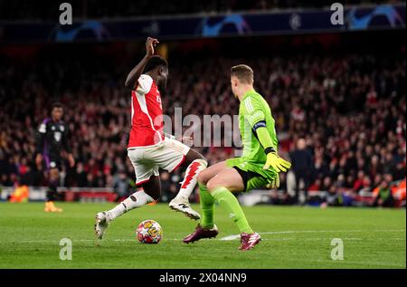 Bukayo Saka d'Arsenal tombe sous le défi du gardien de but Manuel Neuer du Bayern Munich lors du quart de finale de l'UEFA Champions League, match de première manche à l'Emirates Stadium de Londres. Date de la photo : mardi 9 avril 2024. Banque D'Images