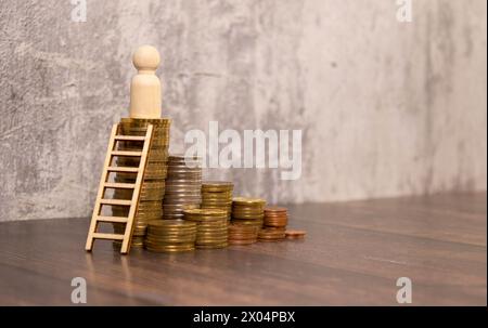 De minuscules modèles d'homme d'affaires miniatures se tiennent sur des piles de pièces de monnaie et regardent l'homme d'affaires prospère et montent l'escalier pour une utilisation réussie Banque D'Images