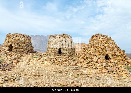 Anciennes tombes de ruches en pierre avec Jebel Misht montagne en arrière-plan, site archéologique près d'al-Ayn, sultanat Oman Banque D'Images