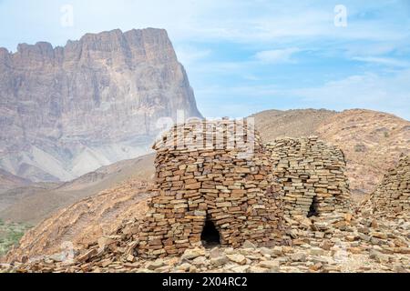 Anciennes tombes de ruches en pierre avec Jebel Misht montagne en arrière-plan, site archéologique près d'al-Ayn, sultanat Oman Banque D'Images