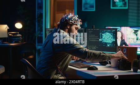 Ingénieur avec casque EEG insérant la cartouche dans le PC pour utiliser un logiciel de haute technologie permettant le transfert du cerveau dans le monde virtuel. Homme mettant le disque dans l'ordinateur pour commencer le téléchargement de conscience, caméra A. Banque D'Images