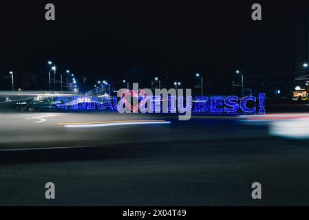 Chisinau vous aime, avec un cœur rouge au centre, écrit en lettres de lumière, illumination nocturne à un rond-point à l'entrée de la ville. Banque D'Images