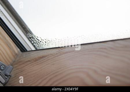 Gros plan de la condensation sur la fenêtre velux dans une maison, des gouttes d'eau et de l'humidité élevée Banque D'Images