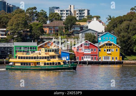 Sydney ferry le Golden Grove passe devant les célèbres ateliers de quai de vue sur l'eau aux couleurs vives sur la péninsule de Balmain, Sydney, Nouvelle-Galles du Sud, Australie Banque D'Images