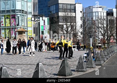 Hommes en chemises jaunes dansant sur le Jingūbashi (pont du sanctuaire) à Harajuku - Jingumae, Shibuya City, Tokyo, Japon – 1er mars 2024 Banque D'Images