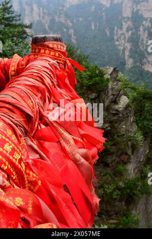 Des rubans de bénédiction rouges et des serrures d'amour bordent les mains courantes dans le parc forestier national de Zhangjiajie dans la zone pittoresque de Wulingyuan, en Chine. Banque D'Images