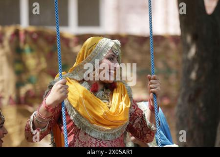 Amritsar. 9 avril 2024. Une femme portant une tenue traditionnelle pendjabi est photographiée sur une balançoire lors d'une foire célébrant le festival Baisakhi dans un collège du district d'Amritsar, dans l'État du nord du Punjab, en Inde, le 9 avril 2024. Baisakhi est l'un des festivals les plus populaires célébrés dans l'État indien du Pendjab pour marquer la récolte. Crédit : Str/Xinhua/Alamy Live News Banque D'Images