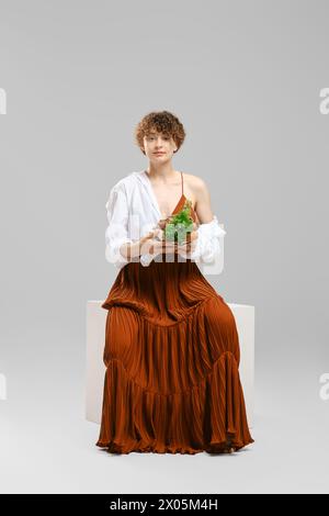 Une jeune femme qui se soucie de sa santé tient un sac en papier avec des légumes et des fruits dans ses mains Banque D'Images