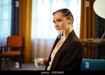 Portrait d'une belle femme élégante avec une coiffure à l'ancienne tenant une tasse de thé dans sa main Banque D'Images