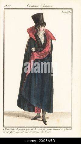 Dandy français en costume de bal et manteau d'opéra doublé de velours, décoré de tresses dorées et de pompons. Haut-de-forme. Manteau de drap, garni de velours, avec tresses et glands d'or, par-dessus un costume de bal. Gravure sur cuivre colorée à la main d’après une plaque mode de Louis Marie Lante du Journal des Dames et des modes de Pierre de la Mesangère, Magazine of Women and Fashion, Paris, 1820. Banque D'Images