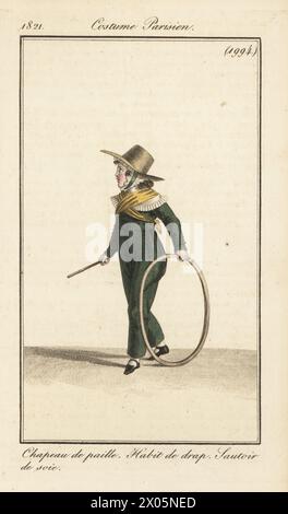 Costume d'un jeune garçon, Paris, 1821. En chapeau de paille, costume de laine vert, foulard en soie, jouer avec un cerceau et un bâton. Chapeau de paille, habit de drap, sautoir de soie. Gravure sur cuivre colorée à la main d’après une plaque mode de Louis Marie Lante du Journal des Dames et des modes de Pierre de la Mesangère, Magazine of Women and Fashion, Paris, 1821. Banque D'Images