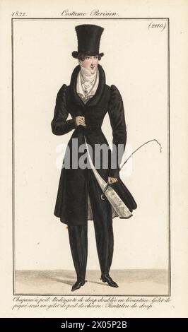 Dandy français en haut-de-chapeau à poils épais, manteau d'équitation doublé de soie Levantine, cravate, gilets en peau de chèvre et piqué, pantalon en laine, tenant un court d'équitation. Chapeau a poil, redingote de drap doublee en levantine, gilet de pique sous un gilet de poil de chevre, pantalon de drap. Gravure sur cuivre colorée à la main d’après une plaque mode de Louis Marie Lante du Journal des Dames et des modes de Pierre de la Mesangère, Magazine of Women and Fashion, Paris, 1822. Banque D'Images