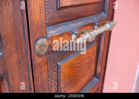 Porte en bois antique avec poignée dorée. Poignée de porte en métal photo en gros plan. Banque D'Images