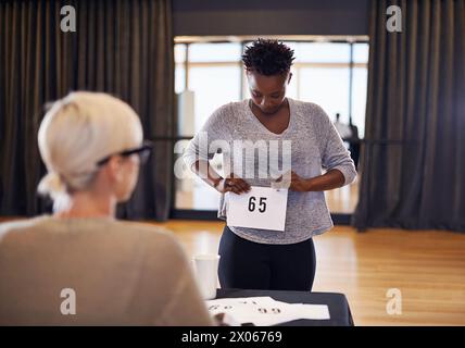 Nombre, juge et femme dans l'audition de casting pour s'inscrire à la performance ou agir sur une scène dans le théâtre. Heureuse actrice, compétition ou danseuse prête pour Banque D'Images