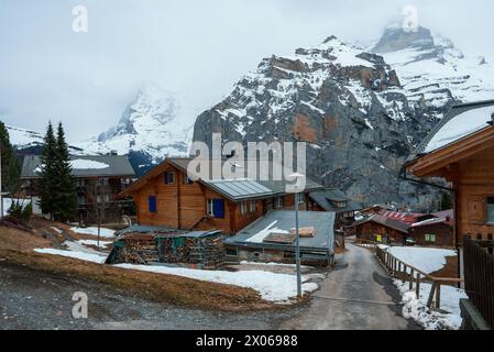 Village de montagne alpin avec toits enneigés et pile de bois de chauffage dans les Alpes suisses Banque D'Images