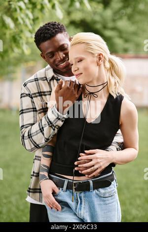 Un homme afro-américain et une femme caucasienne se tiennent ensemble dans un vaste domaine, exsudant le bonheur et l'unité. Banque D'Images