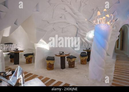 Salon de glace dans la station de ski de Zermatt avec mobilier sculpté et sculpture de glace lumineuse Banque D'Images