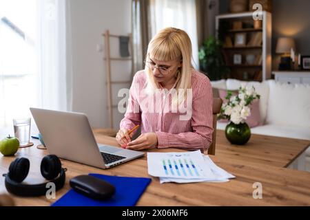 Jeune femme d'affaires indépendante malade travaillant à la maison, travail sur ordinateur portable. Travail à distance en ligne, connexion sans fil féminine avec l'entreprise, faire di Banque D'Images