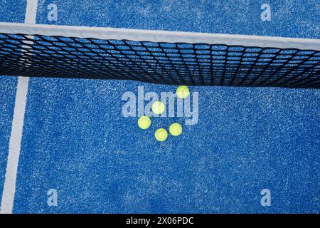 vue de dessus de cinq balles à côté du filet d'un court de paddle-tennis Banque D'Images