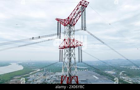 WUHU, CHINE - 10 AVRIL 2024 - des agents de maintenance inspectent le canal kV de À800 sur le fleuve Yangtsé à plus de 270 mètres d'altitude à Wuhu Banque D'Images