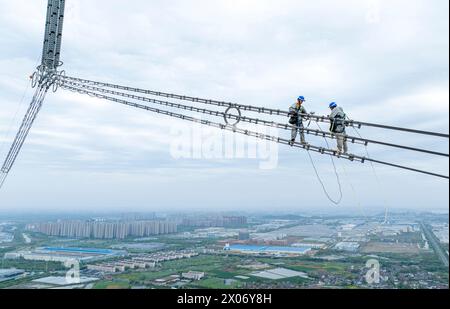 WUHU, CHINE - 10 AVRIL 2024 - des agents de maintenance inspectent le canal kV de À800 sur le fleuve Yangtsé à plus de 270 mètres d'altitude à Wuhu Banque D'Images