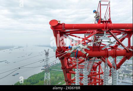 WUHU, CHINE - 10 AVRIL 2024 - des agents de maintenance inspectent le canal kV de À800 sur le fleuve Yangtsé à plus de 270 mètres d'altitude à Wuhu Banque D'Images