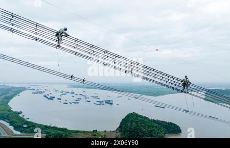 WUHU, CHINE - 10 AVRIL 2024 - des agents de maintenance inspectent le canal kV de À800 sur le fleuve Yangtsé à plus de 270 mètres d'altitude à Wuhu Banque D'Images