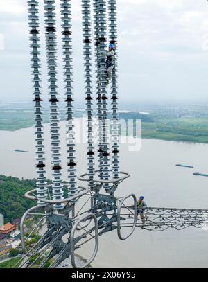 WUHU, CHINE - 10 AVRIL 2024 - des agents de maintenance inspectent le canal kV de À800 sur le fleuve Yangtsé à plus de 270 mètres d'altitude à Wuhu Banque D'Images