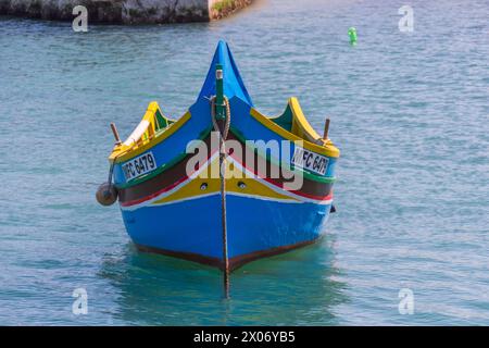 Marsaxlokk, Malte - 23 mars 2022 : le bateau de pêche traditionnel maltais appelé Luzzu amarré dans le port de Marsaxlokk. Ils sont colorés de façon éclatante avec Banque D'Images