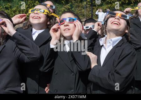 3 étudiants juifs orthodoxes de yeshiva regardent l'éclipse solaire de 2024 dans leur cour d'école. Dans le comté de Rockland, New York. Banque D'Images