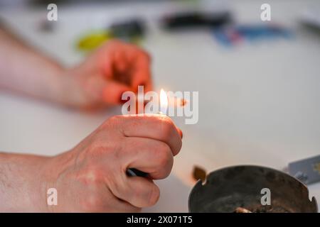 jeune adulte féminin méconnaissable préparer le joint de cigarette de tabac de haschisch de fumée avec filtre à la maison sur la table blanche pour la santé personnelle détendez-nous Banque D'Images