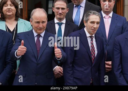 Le nouveau Taoiseach Simon Harris (à droite) avec Tanaiste Micheal Martin (à gauche) avant une séance photo avec ses ministres d'État nouvellement nommés sur les marches des bâtiments du gouvernement à Dublin. Date de la photo : mercredi 10 avril 2024. Banque D'Images