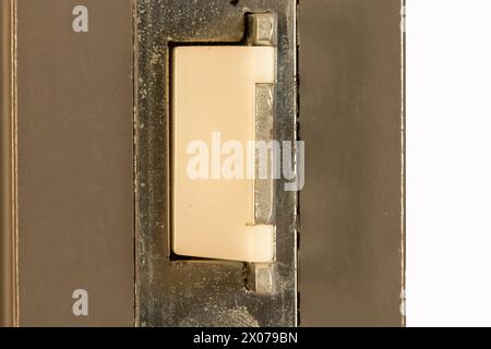 Gros plan du loquet de porte moderne avec du plastique blanc et du métal. Banque D'Images