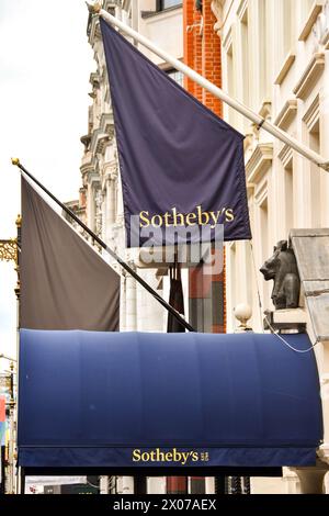 Londres, Angleterre, Royaume-Uni - 27 juin 2023 : drapeau et verrière au-dessus de l'entrée de la maison de vente aux enchères Sotheby's à New Bond Street dans le centre de Londres Banque D'Images
