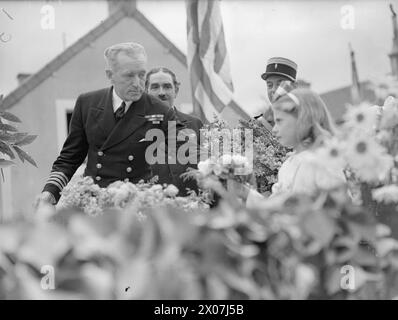 Le 14 juillet 1944, le jour de la Bastille à Arromanches comprenait une cérémonie avec des représentants de la Royal Navy, de l'armée britannique et de l'armée de l'air. Les Royal Marines fournissent une garde d'honneur, et le capitaine H Hickling reçoit un bouquet d'une française. Banque D'Images